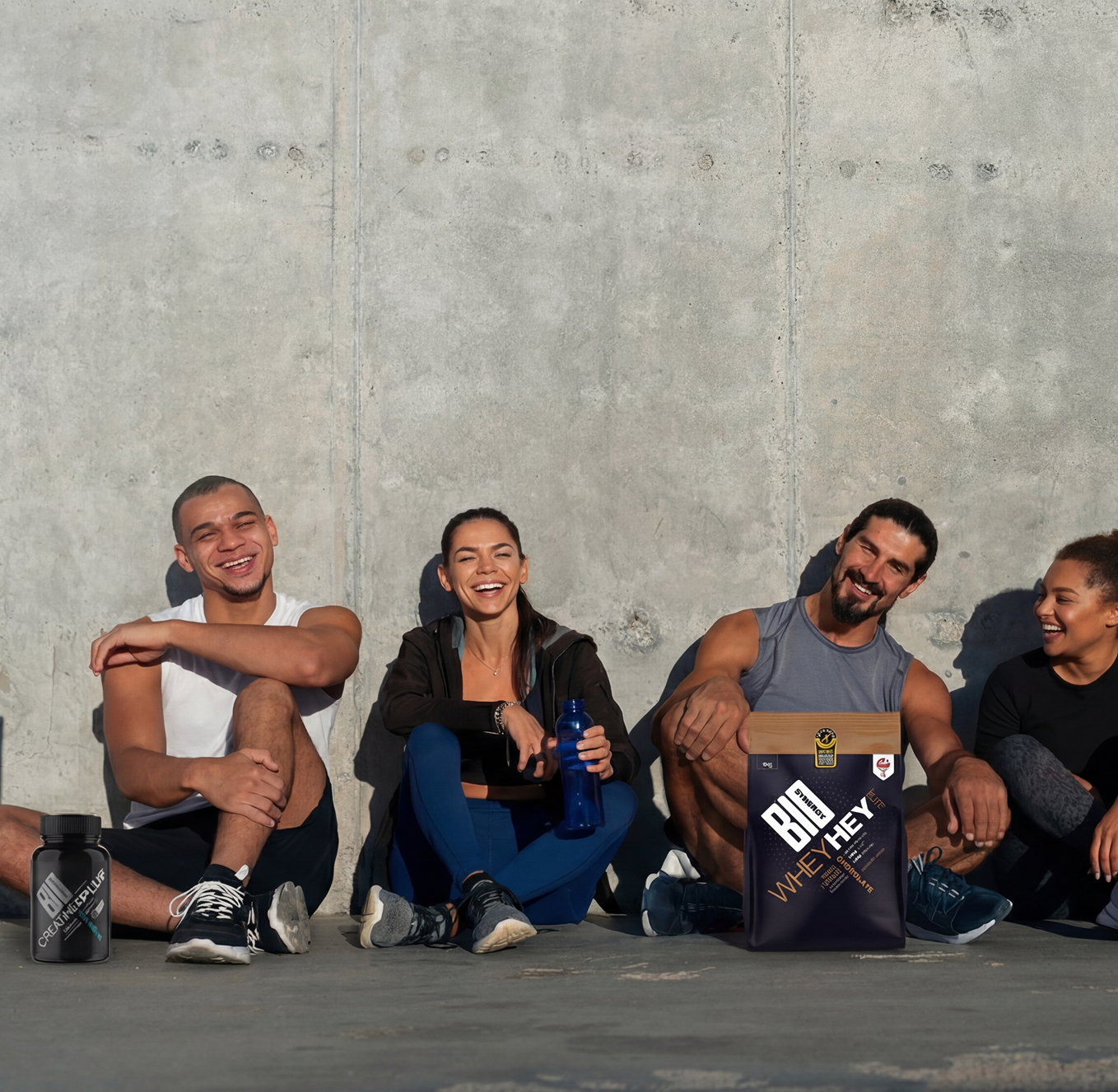 Group of diverse athletes sitting on floor with Bio-Synergy supplements